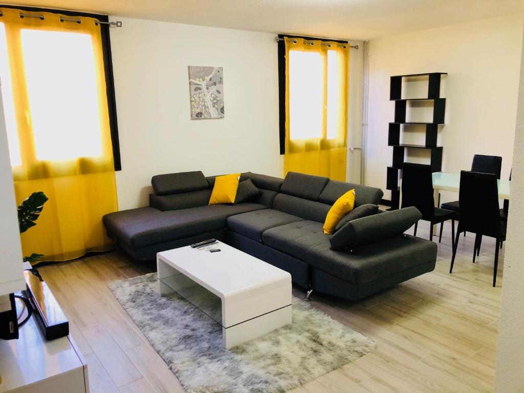 托农莱班Bella vita的客厅配有黑色沙发和黄色枕头