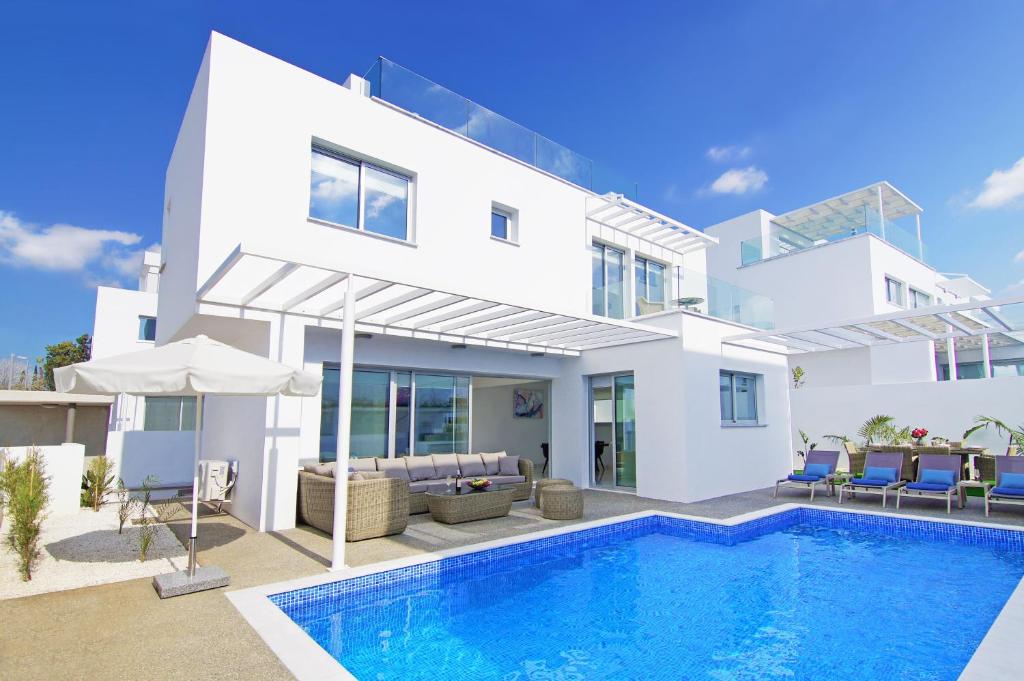 阿依纳帕Villa Paradisia的一座白色的房子,前面设有一个游泳池