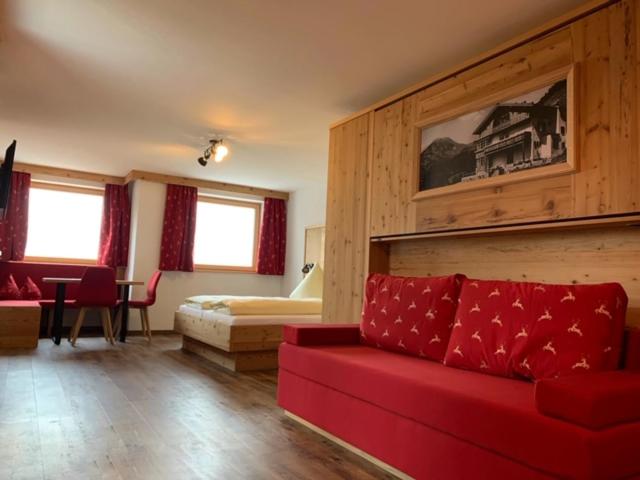 奥博奥多夫胡蒙雷贝格酒店的一间带红色沙发的客厅和一间卧室