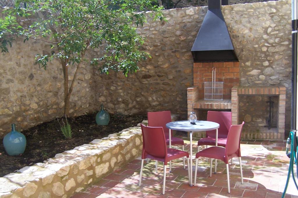OrtellsApartamentos Bergantes的庭院配有桌椅和壁炉。