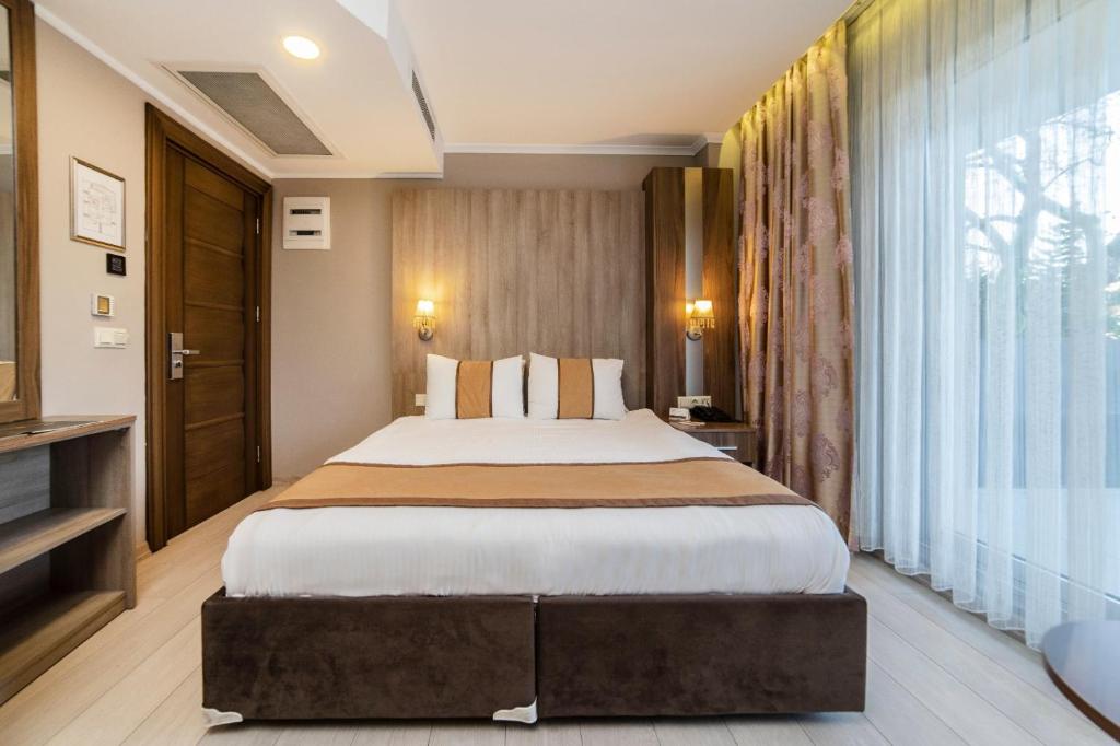 ÇekirgeTurk Inn Ferro Hotel的一间卧室设有一张大床和一个大窗户