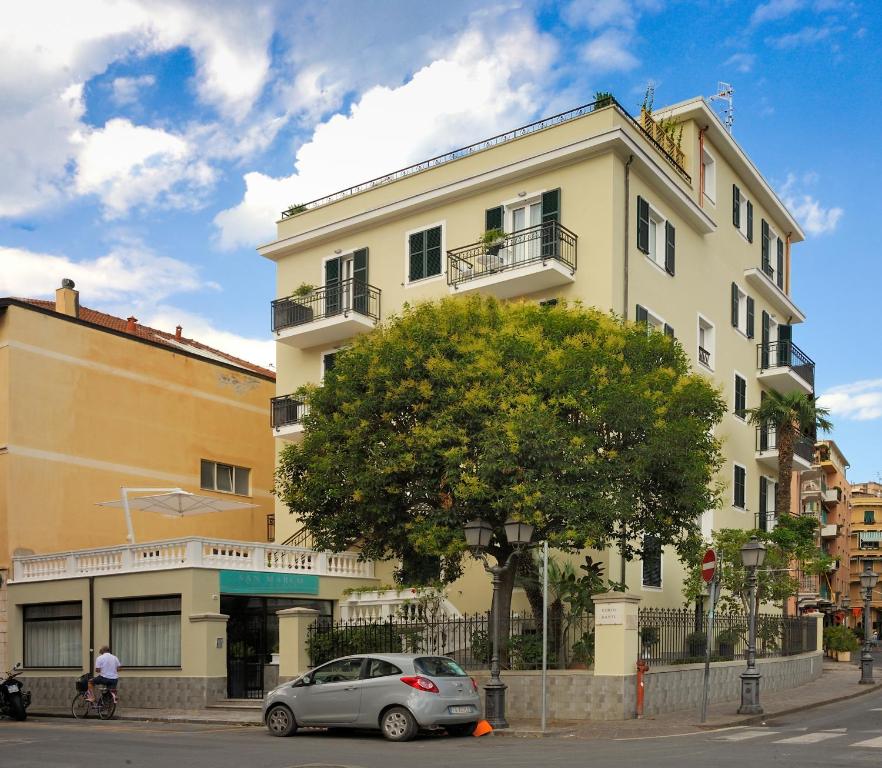 阿拉西奥Residence San Marco Suites&Apartments Alassio的前面有一辆汽车停放的白色建筑