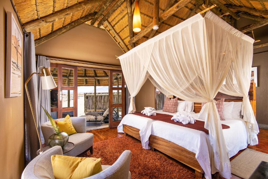 塞斯瑞姆Hoodia Desert Lodge的一间卧室配有一张带天蓬的大床