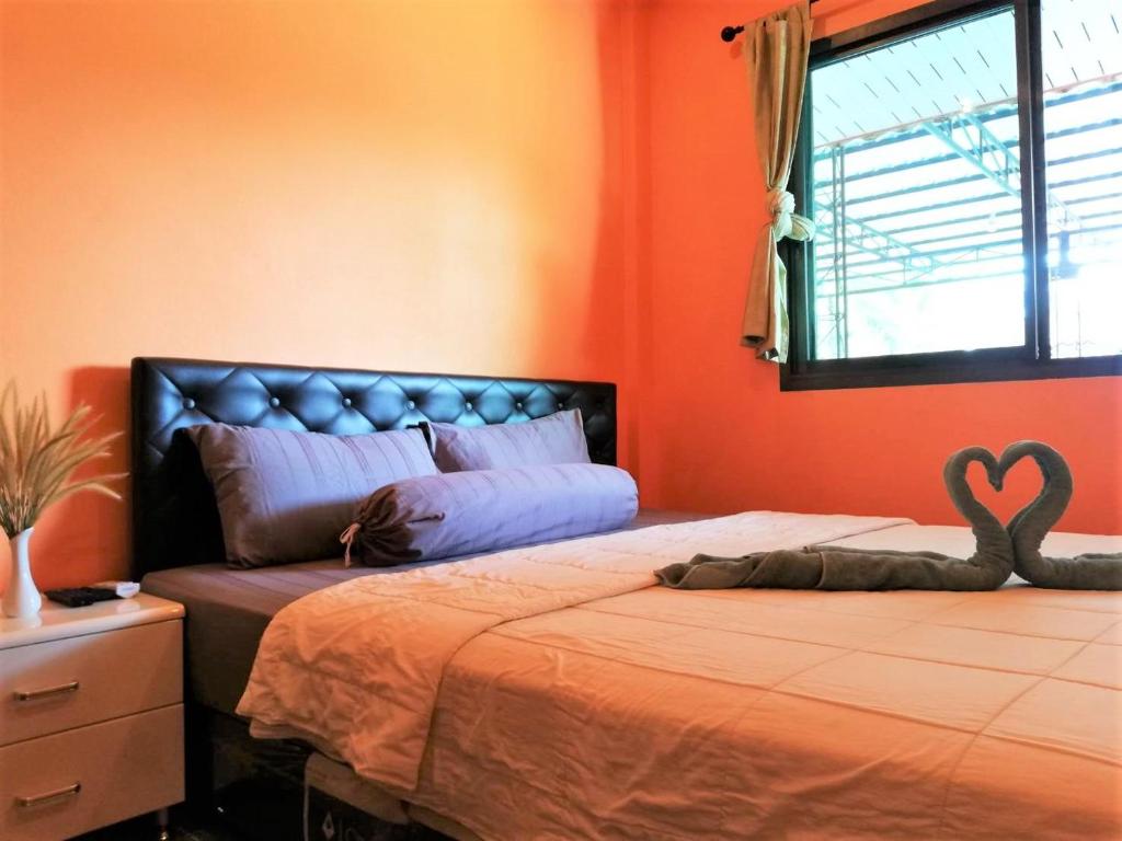 攀牙府Phurafa Resort的一间卧室配有一张带心枕的床