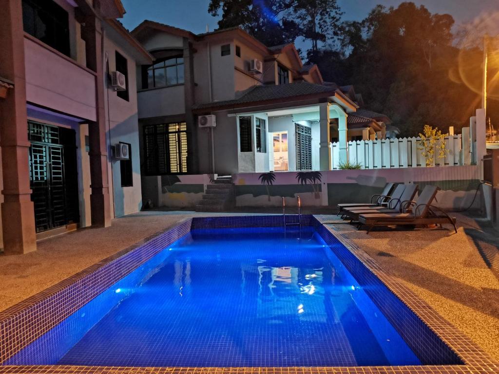 瓜埠Fuxi fruit garden villa Langkawi 富囍休闲度假水果园别墅兰卡威的夜间在房子前面的游泳池
