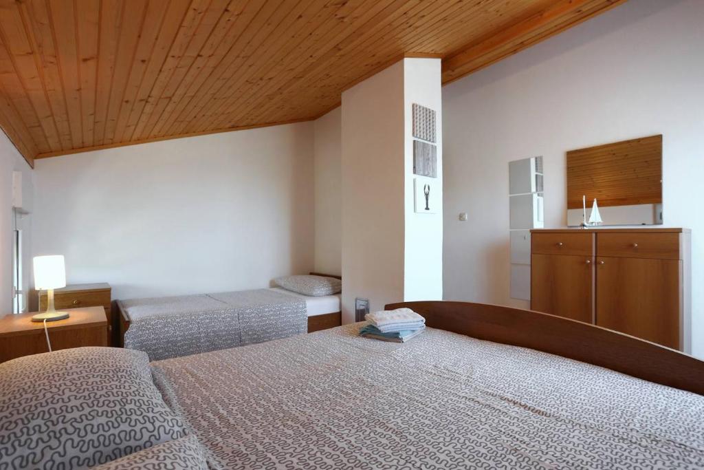 维拉斯奇Little Heaven on Earth - Apartmani Martina的一间卧室设有两张床和木制天花板