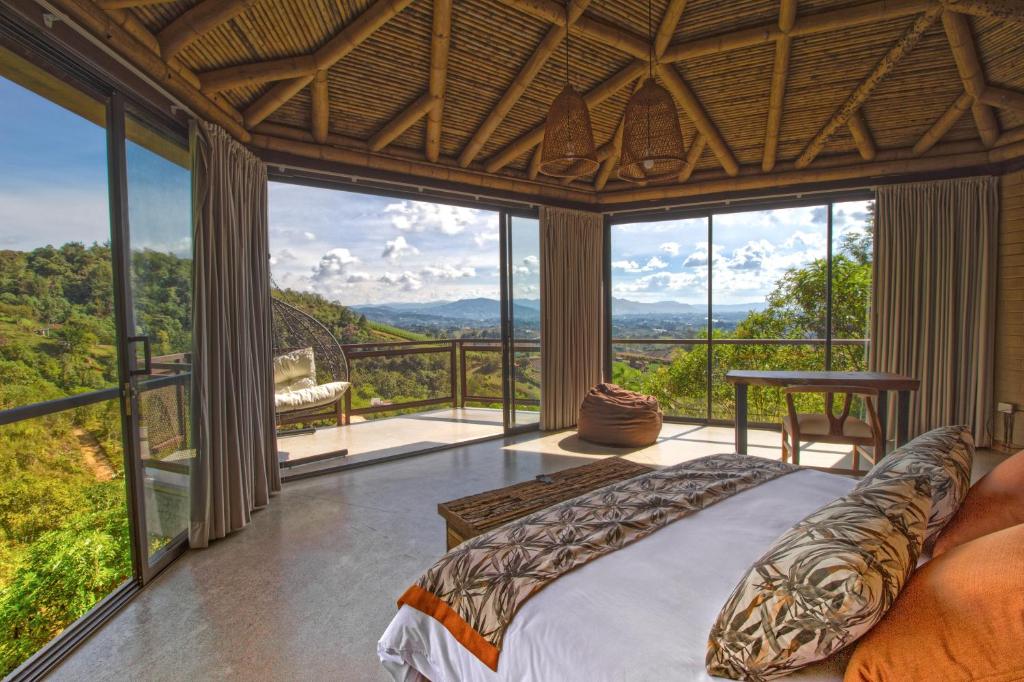 马里尼亚Cannua Lodge的一间卧室设有床铺和大型玻璃窗