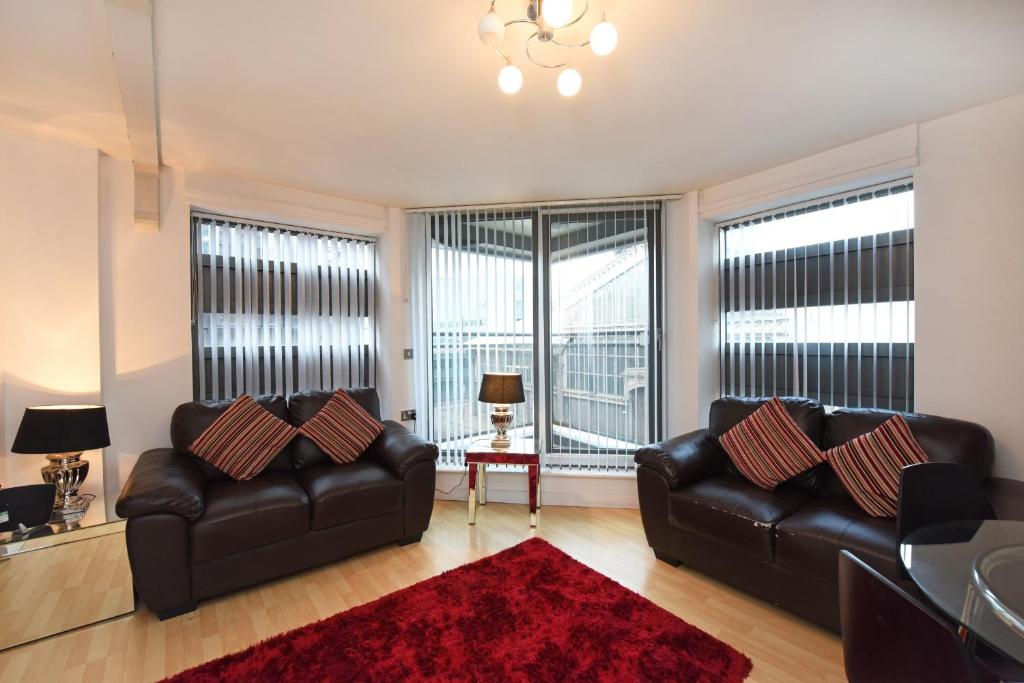 曼彻斯特曼切斯特丁斯盖特梦之屋酒店的客厅配有两张真皮沙发和红色地毯