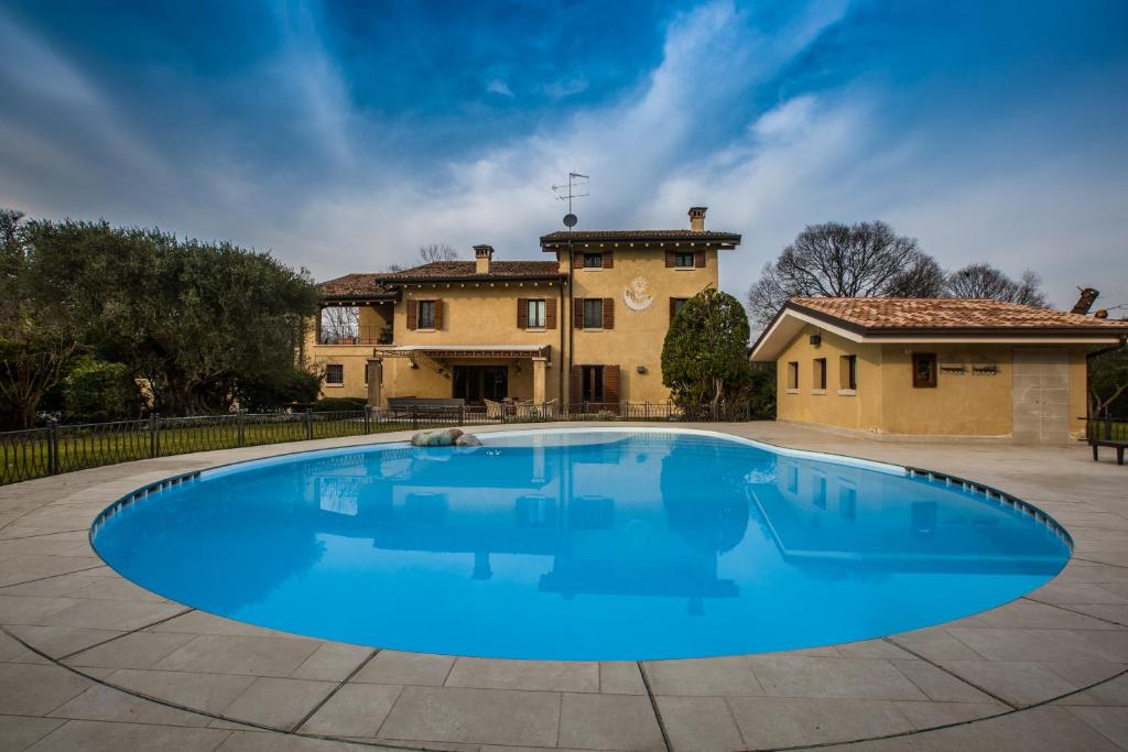 明乔河畔蓬蒂Casale la Meridiana的一座大蓝色游泳池,位于房子前