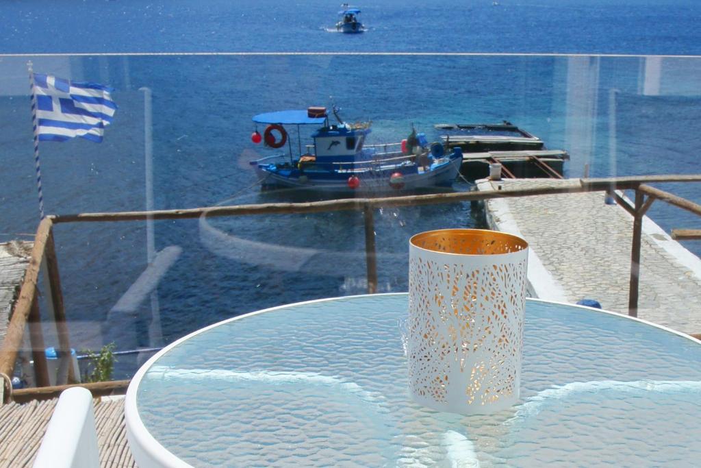 卡利诺岛Afrodite Luxury Rooms的桌子上带船的花瓶