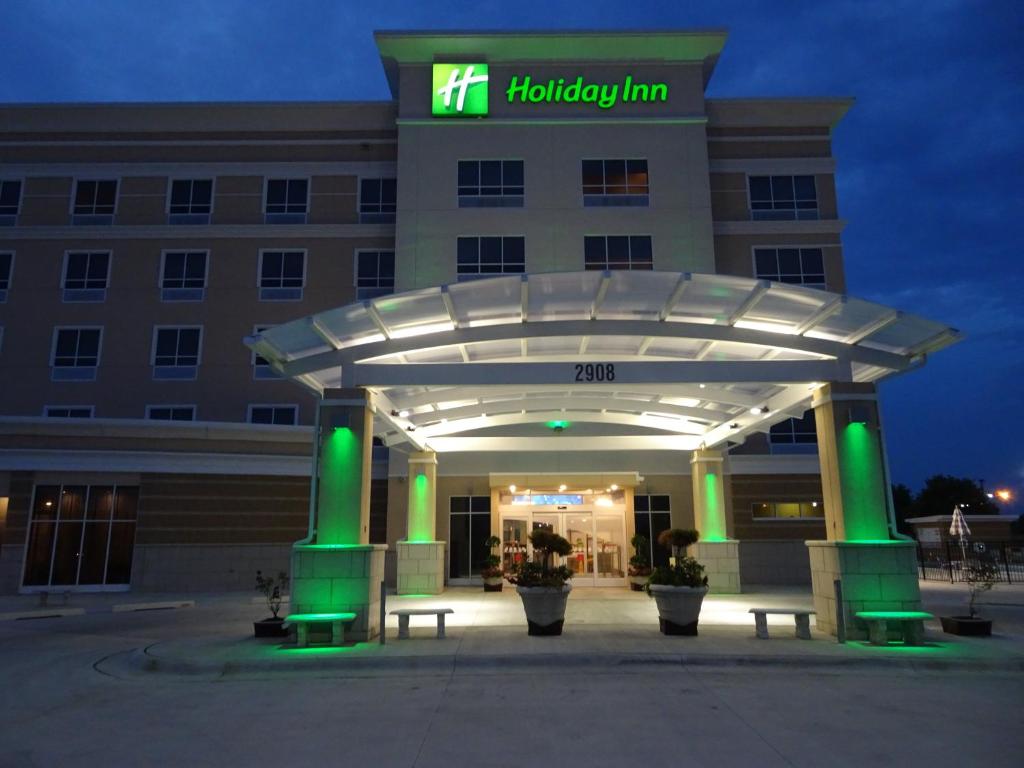 琼斯伯勒Holiday Inn - Jonesboro, an IHG Hotel的医院大楼,晚上有灯入口