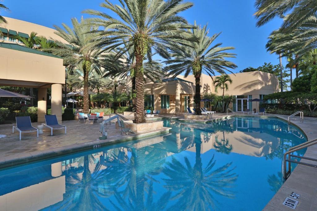 迈阿密多罗尔西迈阿密洲际酒店的一座棕榈树游泳池和一座房子