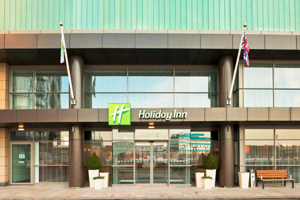 曼彻斯特假日曼切斯特-传媒之城酒店的霍尔茨曼旅馆大楼前方有旗帜