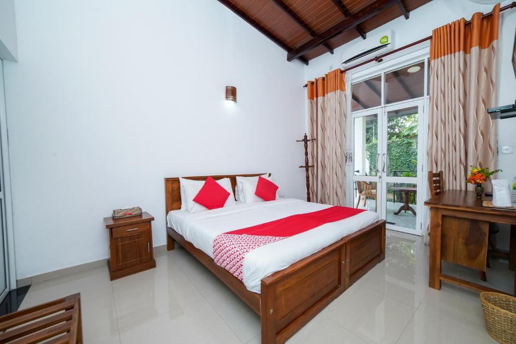 康提Dazzling Villa的一间卧室配有一张带红色枕头的床和一扇窗户