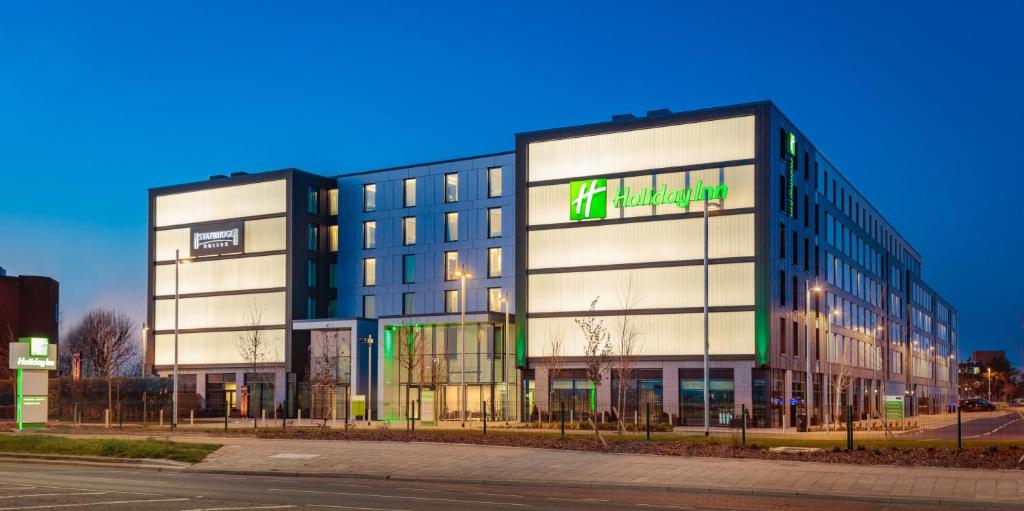 希灵登Holiday Inn London Heathrow - Bath Road, an IHG Hotel的一座大建筑,上面有绿色的标志