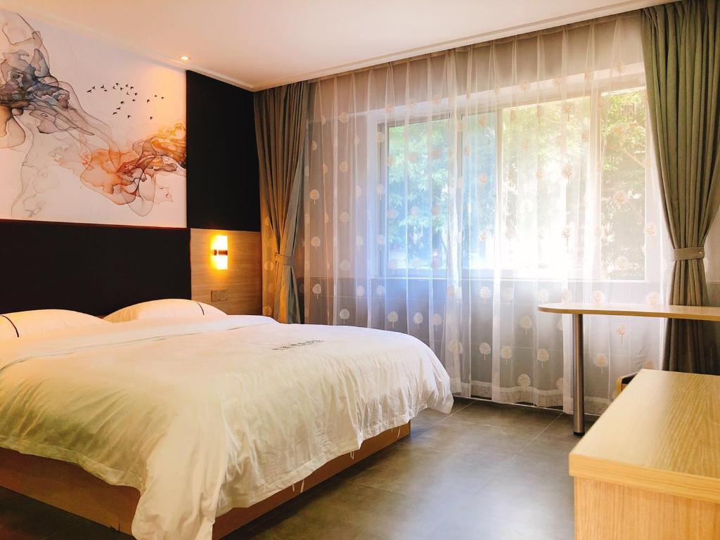 深圳深圳市华联精品酒店的一间卧室设有一张床和一个大窗户