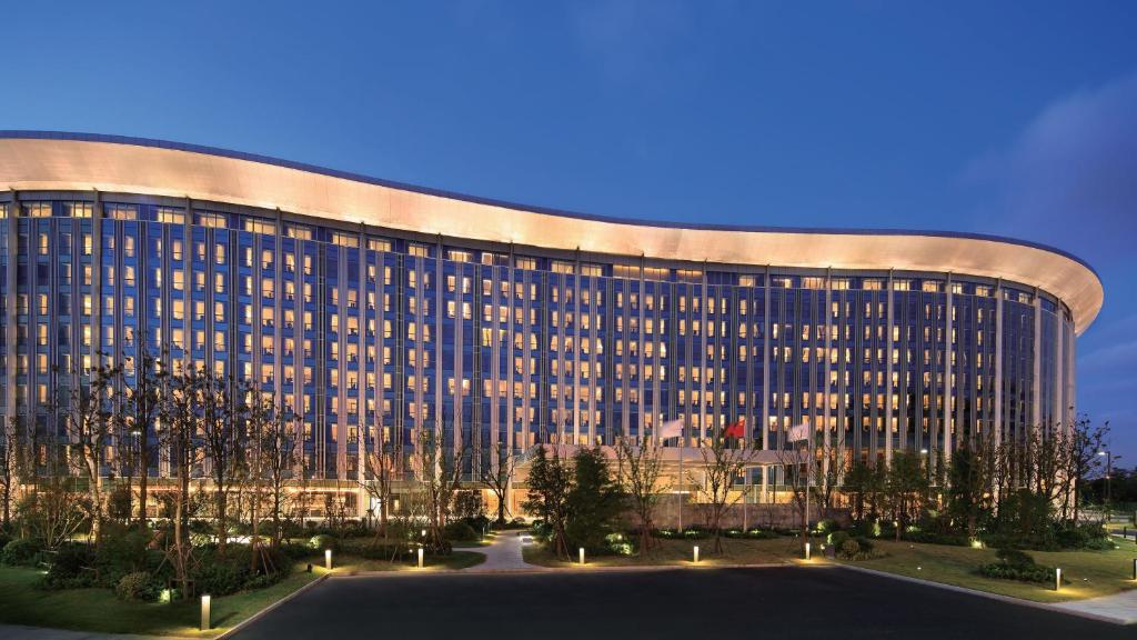 上海国家会展中心上海洲际酒店的一座在晚上有弧形外观的大型建筑