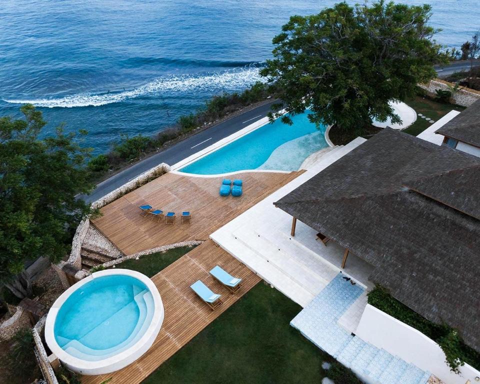 珀尼达岛Villa Victoria Nusa Penida的享有毗邻大海的游泳池的顶部景致