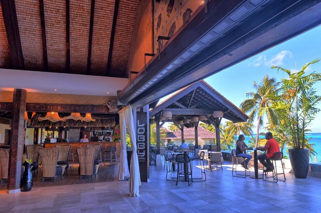 帕皮提大溪地洲际spa度假酒店的海滩上的餐厅,有人坐在桌子旁