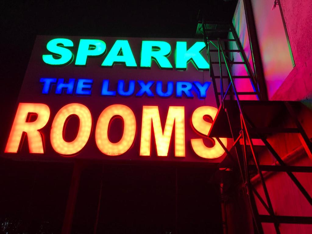 钦奈HOTEL SPARK RESIDENCY的 ⁇ 虹灯标志,显示豪华客房的火花