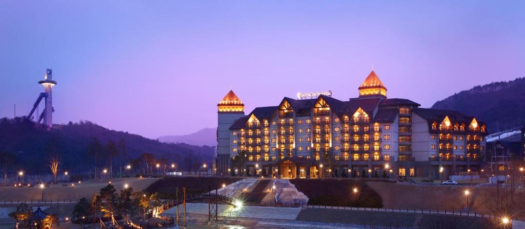 平昌平昌阿尔帕西亚洲际度假酒店的一座大建筑,上面有灯,晚上
