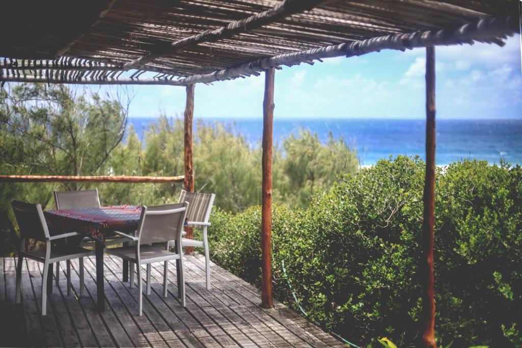 托弗海滩Tofinho Beach House的一个带桌椅的庭院和大海