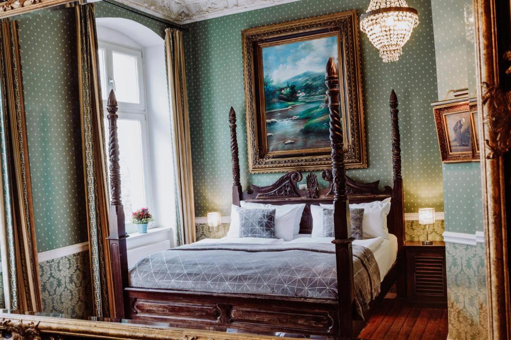 柏林霍宁格莫地精品酒店的一间卧室设有天蓬床和大镜子
