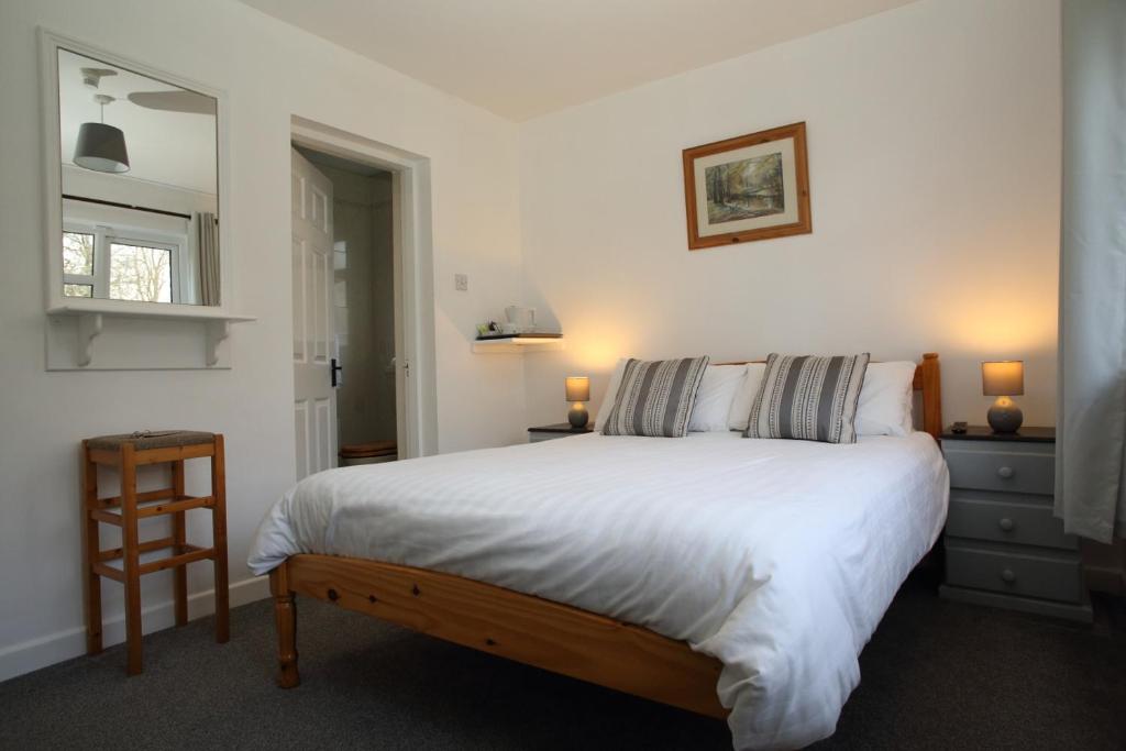 戈里Riverfield Bed and Breakfast的卧室配有一张白色大床和一把椅子