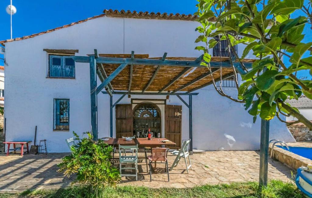 Ojuelos AltosCasa Rural Ermita Azul的房屋前设有带桌椅的天井。