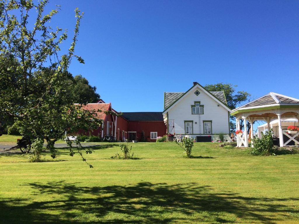 StraumenStrømnes - Oldefars gjestehus Inderøy的一座大白色房子,在院子里设有凉亭