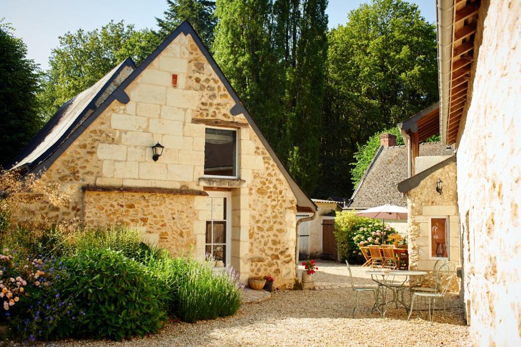 Rigny-UsséDomaine de la Juranvillerie, gîte et chambres d'hôtes的庭院内带庭院的石头房子