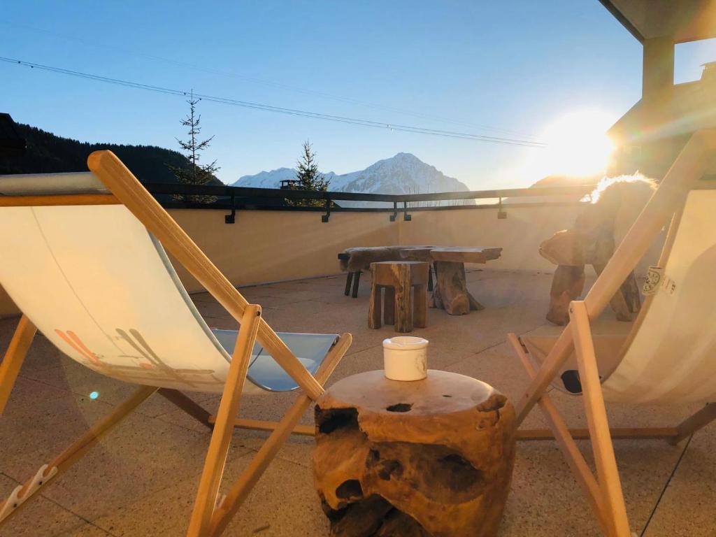 沃雅尼Appartement cocooning - Grande terrasse - bain nordique-Sauna - DOMAINE DU PATRE的庭院里摆放着几把椅子和一张桌子