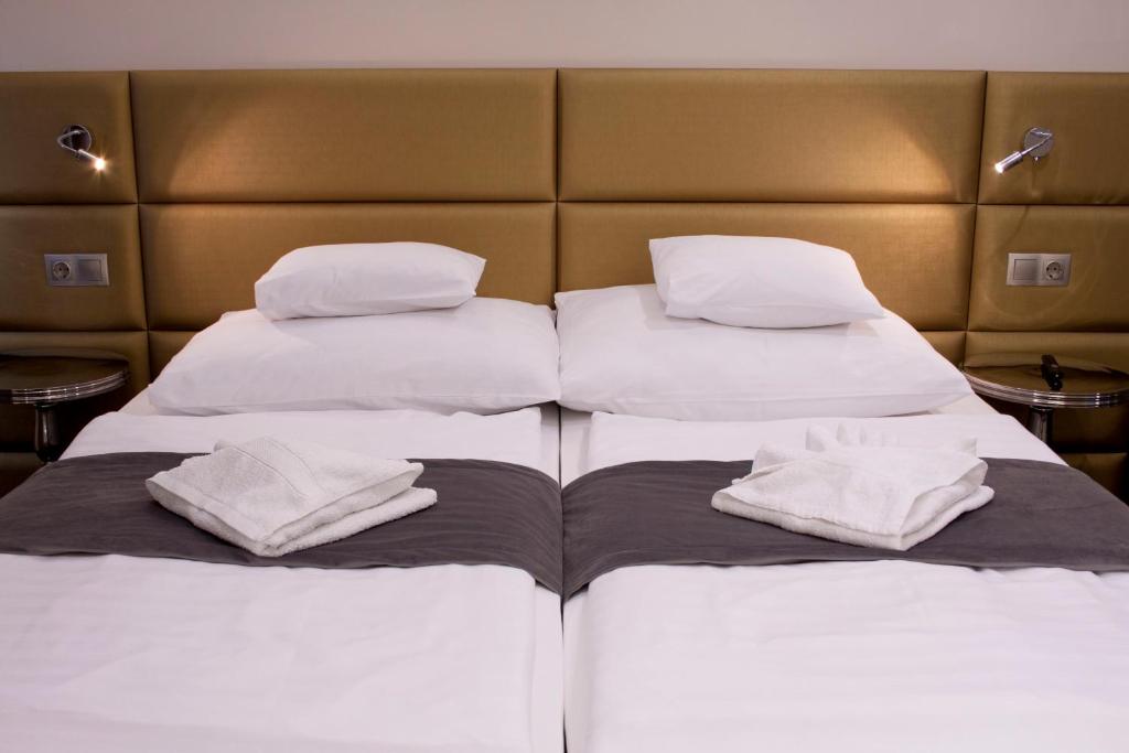 杰尔Relax Panzió的配有2张床的带白色床单和枕头的客房