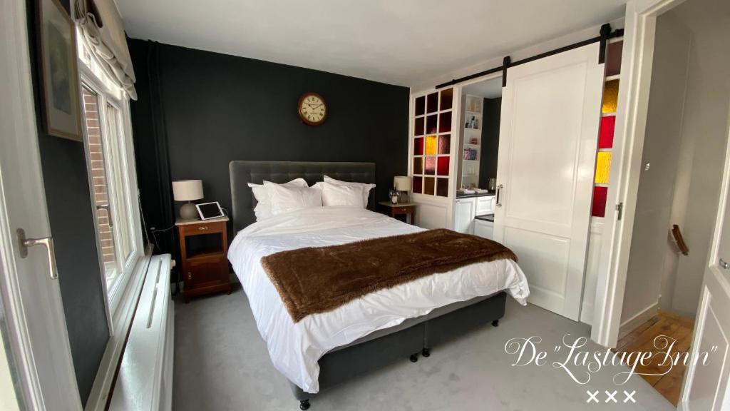 阿姆斯特丹The Lastage Inn - Bed & Breakfast的卧室配有一张床,墙上挂着一个钟