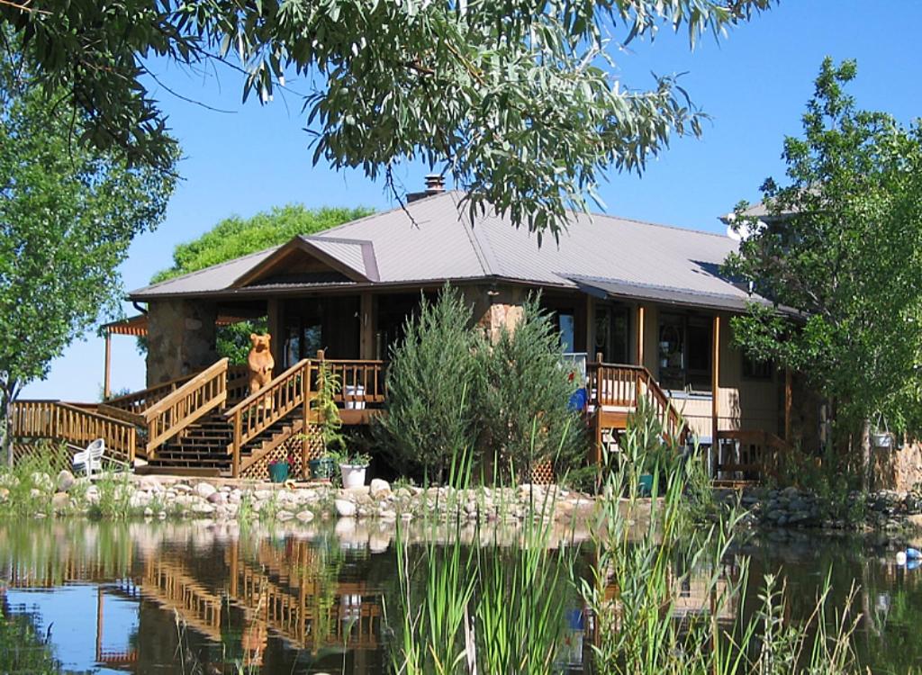 MancosStarry Nights Ranch Bed & Breakfast的前面有池塘的房子