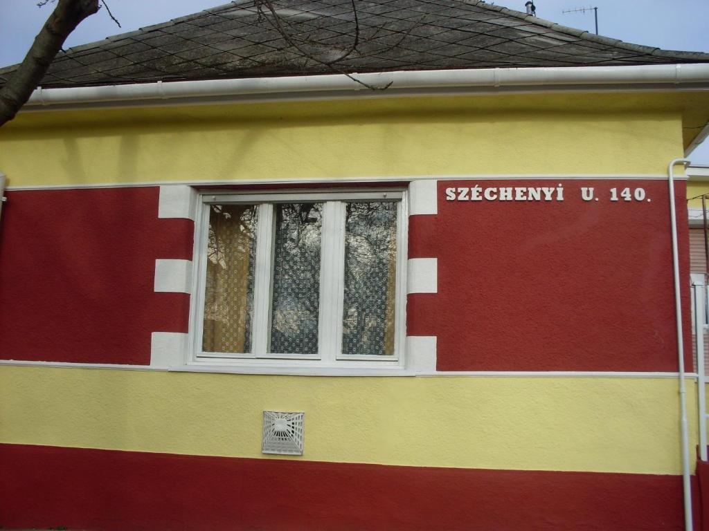 KerekegyházaKereki Retro Vendégház的红色的黄色和红色的房子,有窗户