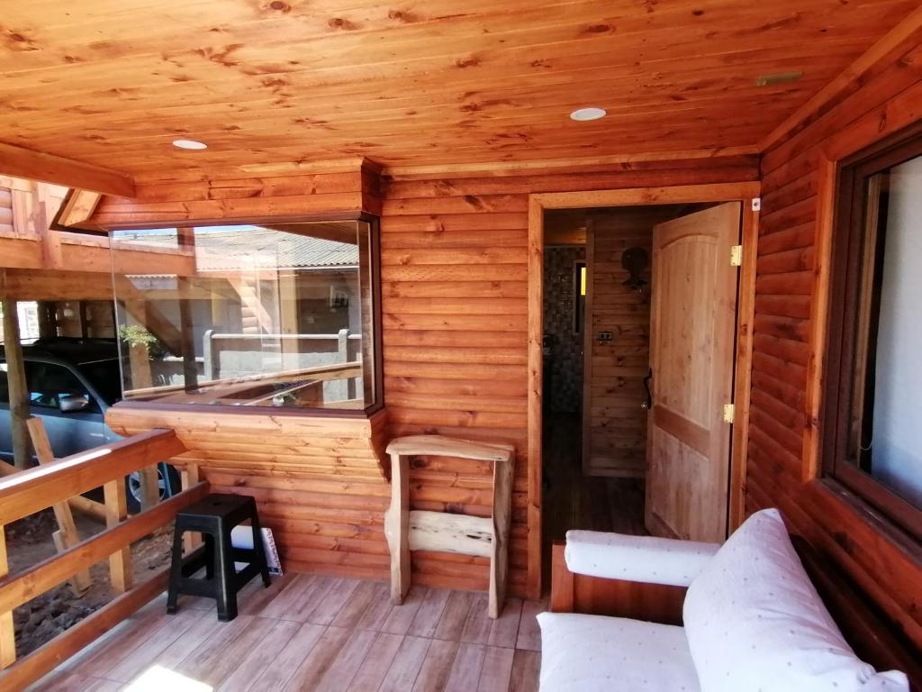 埃尔基斯科Cabaña sol y luna的小屋设有木墙和带长凳的门廊