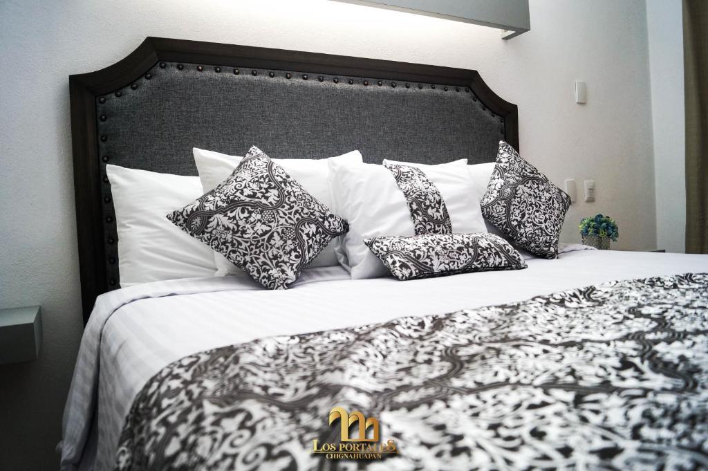 奇格纳瓦潘HOTEL LOS PORTALES CHIGNAHUAPAN的一张带黑白枕头的床