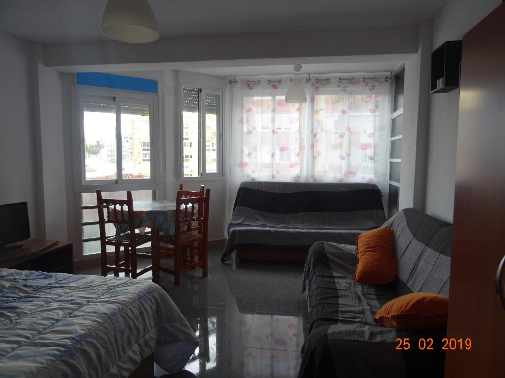 托雷德尔马尔Estudio Plazamar的一间卧室配有两张床和一张桌子及椅子
