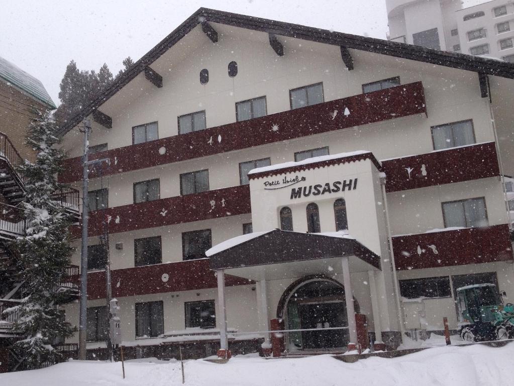 汤泽町苗场武藏宾馆的一座大建筑,前面有雪落