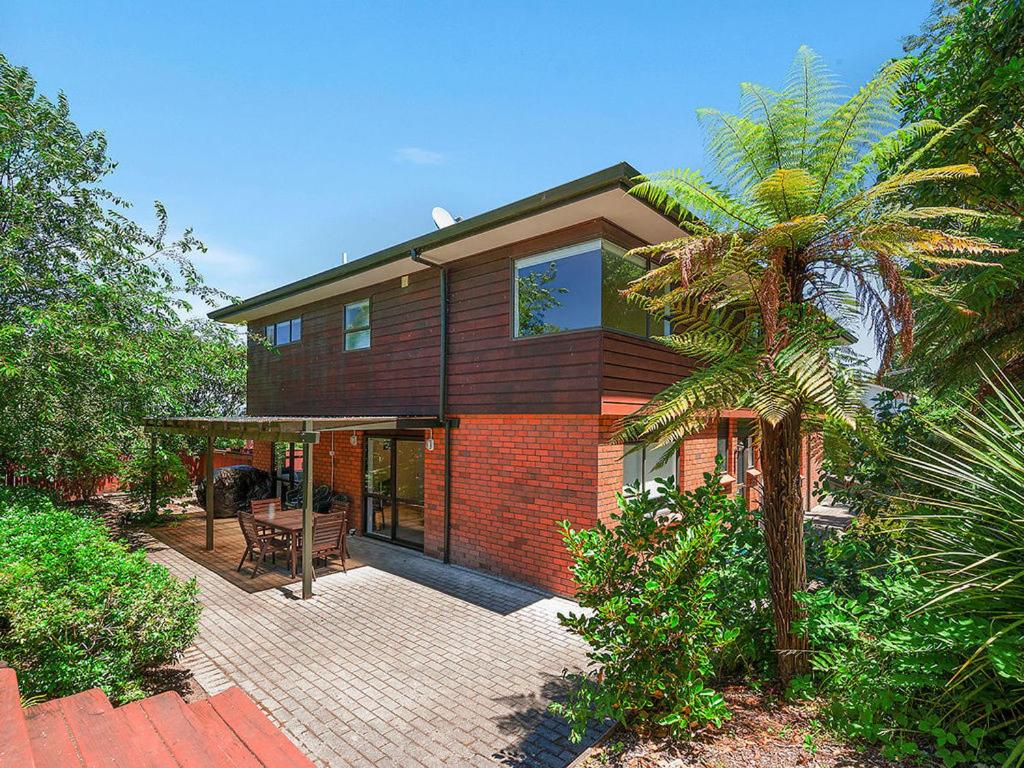 陶波Acacia Bay Getaway - Lake Taupo Holiday Home的前面有棕榈树的房子