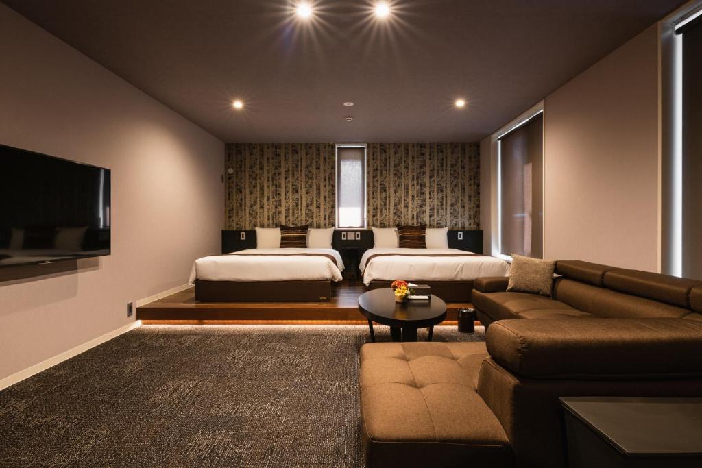 北九州GRAND BASE Moji Nagomi的一间带两张床和一张沙发的客厅