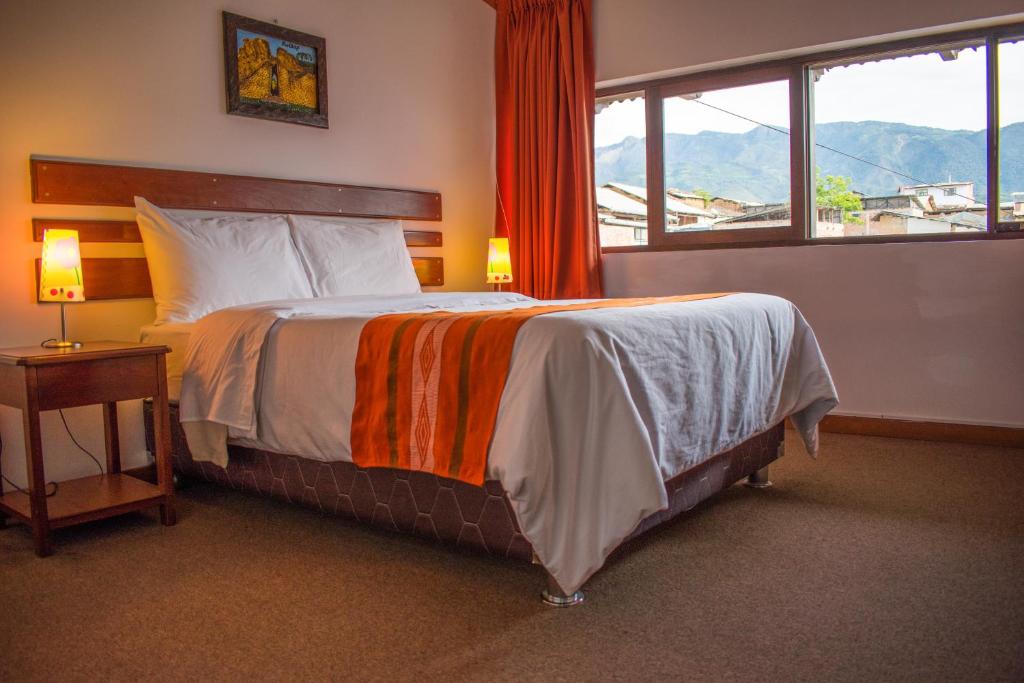 查查波亚斯Explorer Deluxe Hotel的一间卧室设有一张大床和一个窗户。