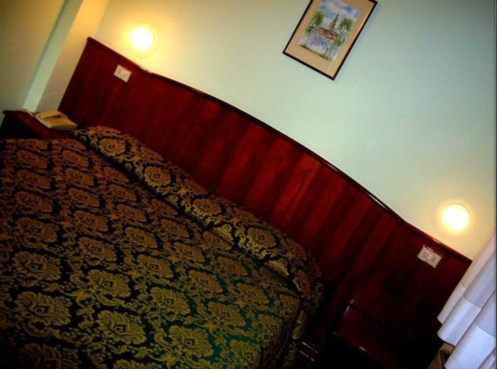 波图格鲁洛阿尔伯格梅里迪娜酒店的一间卧室配有一张红色床头板的床