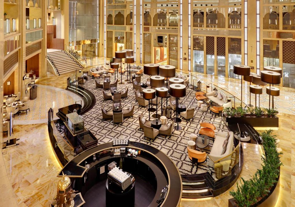 迪拜迪拜H酒店的大楼内带桌椅的大型大堂