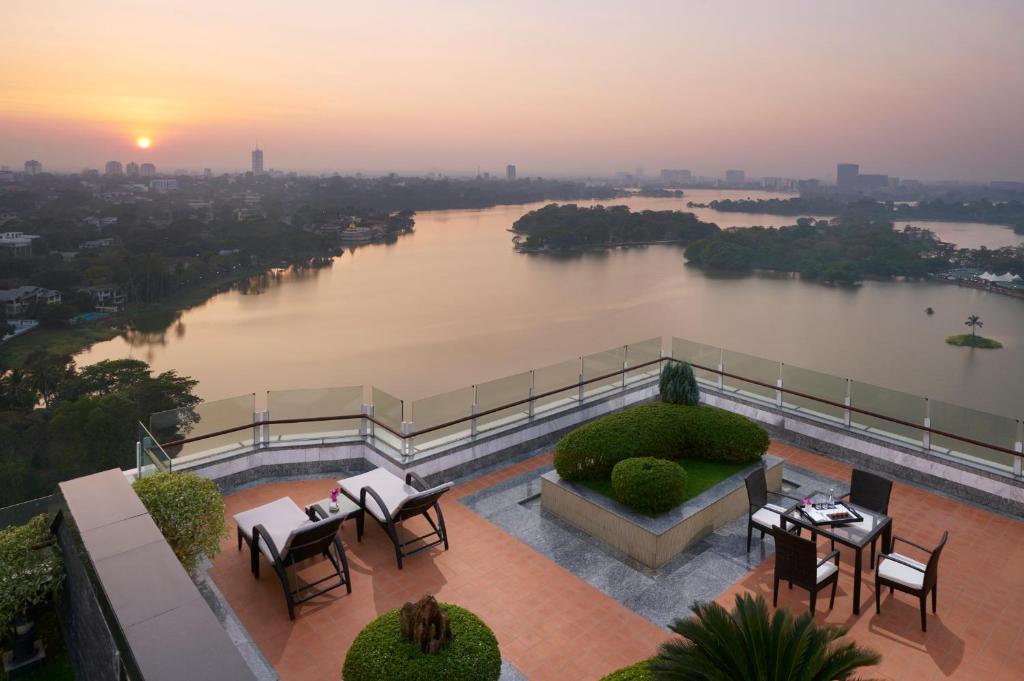 仰光仰光梅里亚酒店的阳台享有河景,配有桌椅。