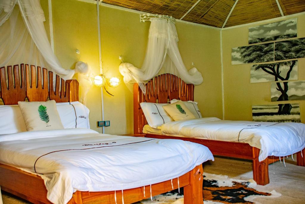 SekenaniMara Chui Eco-Resort的一间卧室配有两张带白色床单的床