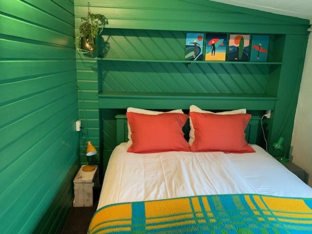 西泰尔斯海灵阿尔提耶德瓦德住宿加早餐酒店的绿色客房内的一张带红色枕头的床