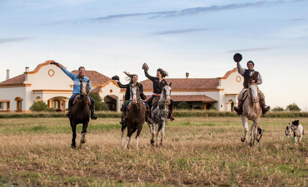 Santa CatalinaEl Colibri - Relais & Châteaux的一群在田野里骑马的人