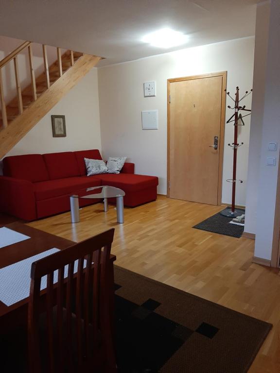 派尔努Õhtukese Apartment的客厅设有红色的沙发和木地板